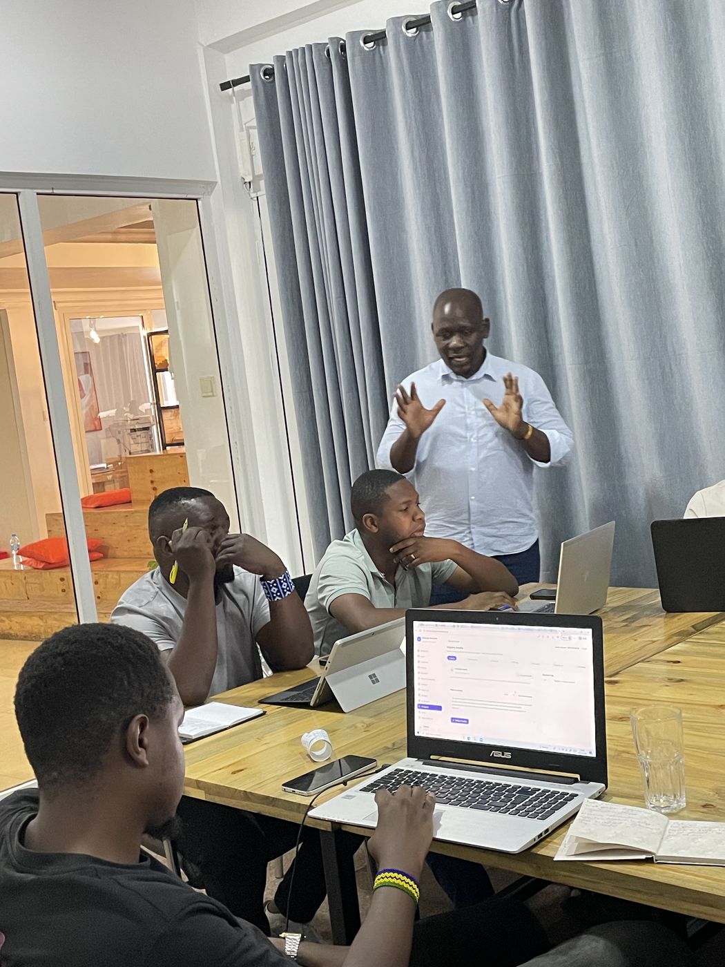 Facilitator explaining while founders work on laptops